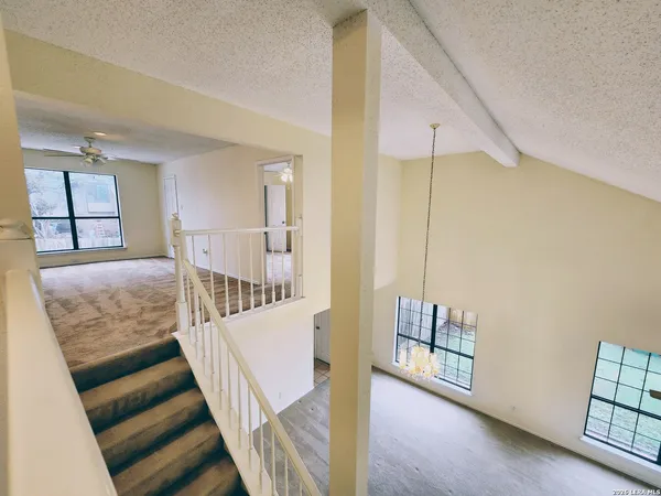 a view of a hallway with furniture and wooden floor