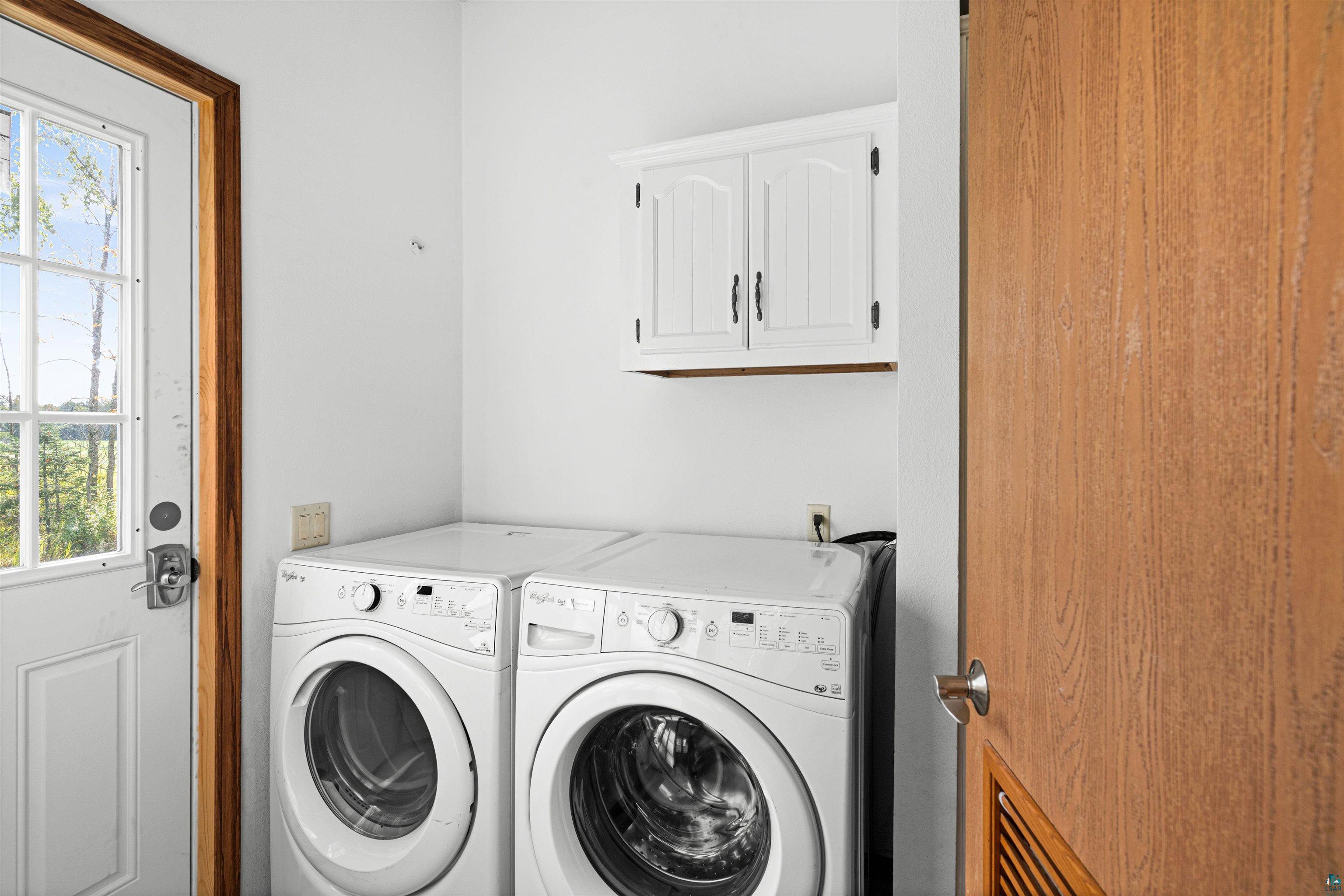 3126 Beyer Road Duluth, MN 55804 - Photo 15 of 23 Dedicated laundry space featuring white wall-mounted cabinetry, white walls, and a windowed exterior door