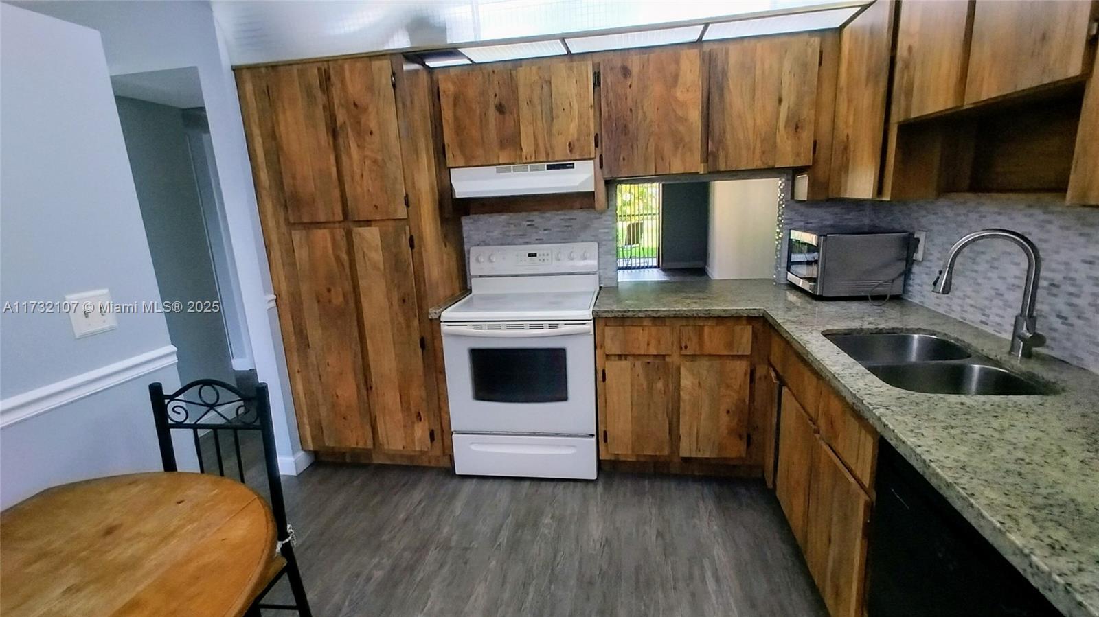 250 Gate Road, Unit 160 Hollywood, FL 33024 - Photo 7 of 33 a kitchen with a sink a refrigerator and a stove top oven