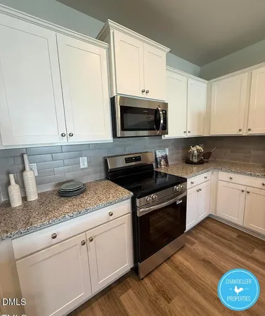 a kitchen with granite countertop a sink a stove and cabinets