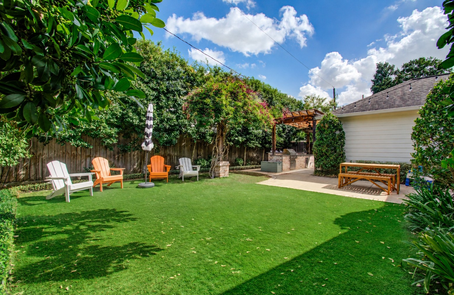 1722 Chippendale Road Houston, TX 77018 - Photo 32 of 41 Charming backyard oasis featuring a lush lawn and cozy pergola with an outdoor kitchen, perfect for entertaining and relaxation.