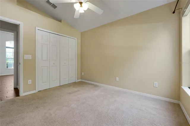 a view of an empty room with a chandelier fan