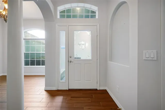 an empty room with wooden floor and a window