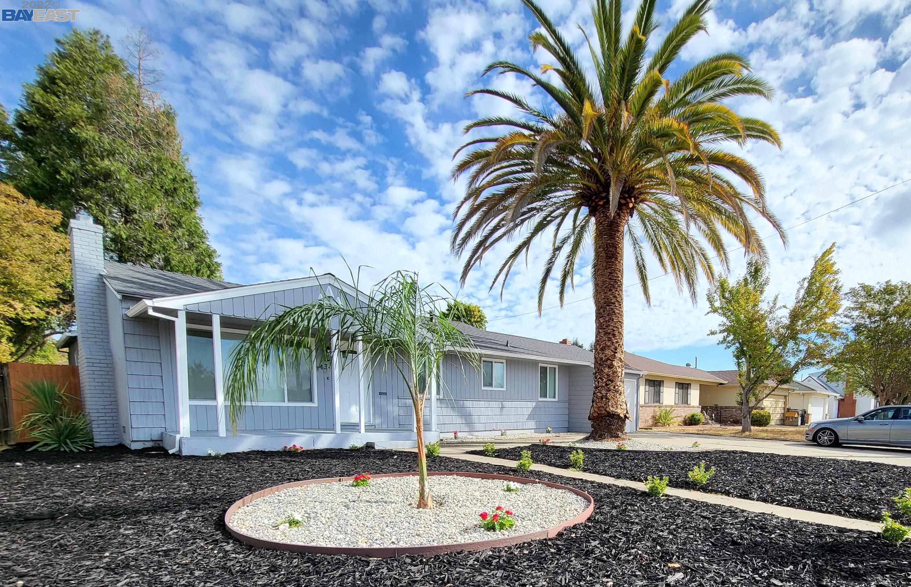 a front view of a house with a garden and patio