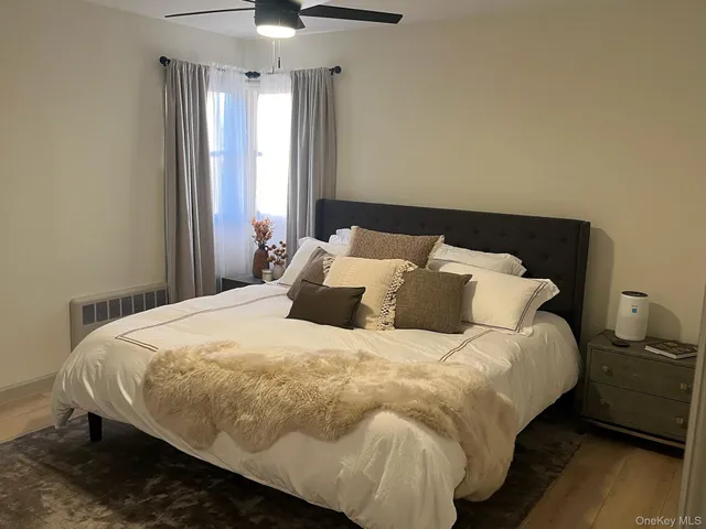 a large bed sitting in a bedroom next to a window and a chandelier