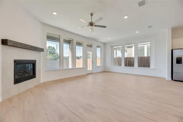 a view of an empty room with a fireplace and a window