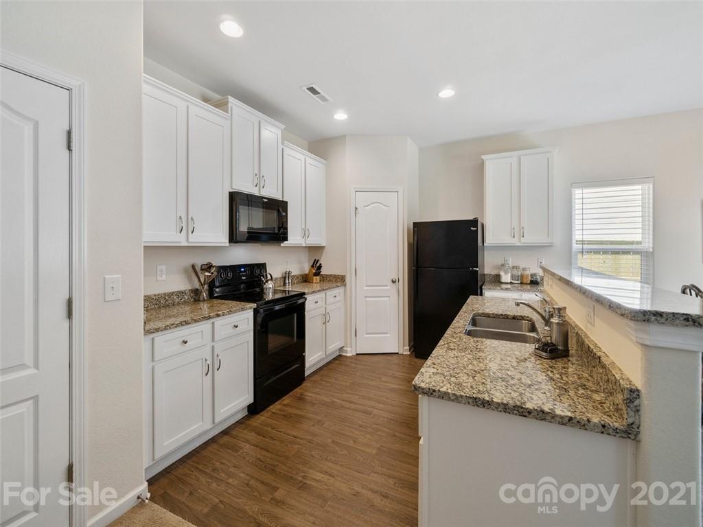 6823 Ware Road Charlotte, NC 28212 - Photo 12 of 47 a kitchen with granite countertop stainless steel appliances white cabinets and a refrigerator
