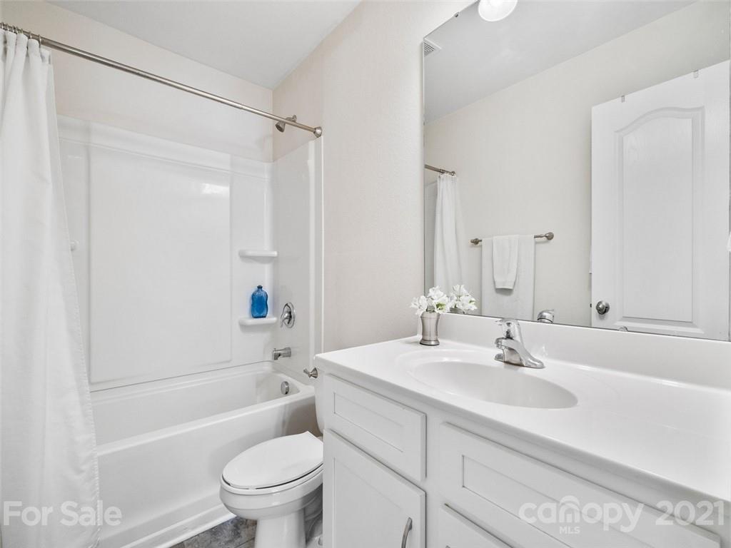 6823 Ware Road Charlotte, NC 28212 - Photo 32 of 47 a bathroom with a sink a toilet and a large mirror