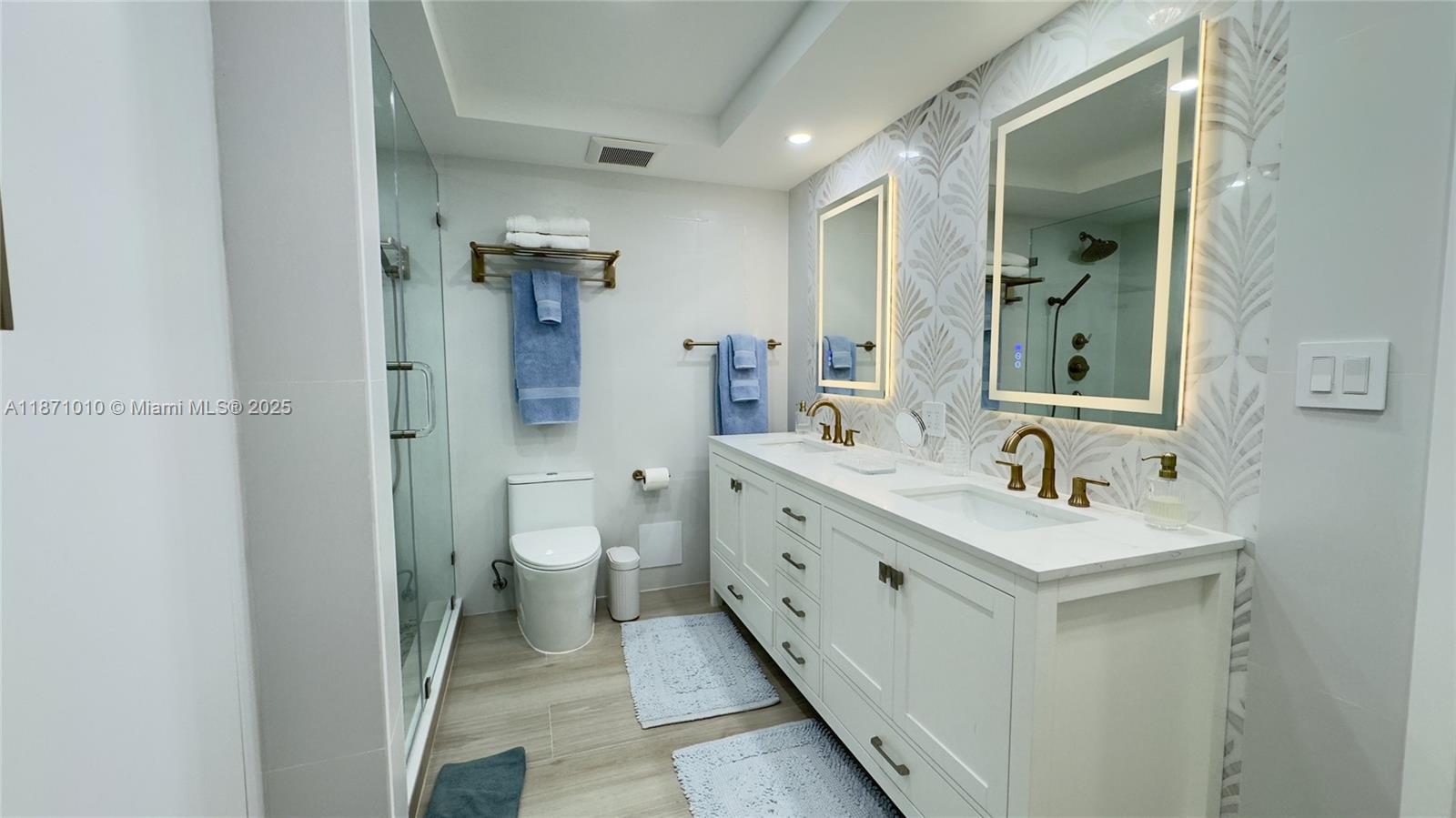 5161 Collins Avenue, Unit 715 Miami Beach, FL 33140 - Photo 11 of 31 a bathroom with a double vanity sink mirror and toilet