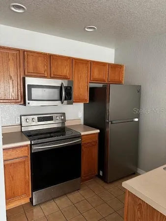a kitchen with a refrigerator stove and cabinets