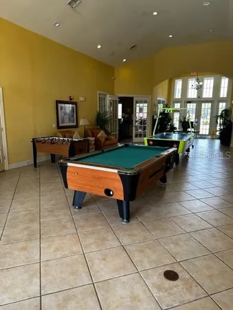 a gym room with pool table and windows