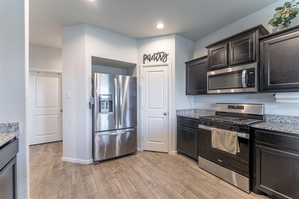 9712 Cherryville Road Fort Worth, TX 76108 - Photo 11 of 27 a kitchen with stainless steel appliances granite countertop a refrigerator microwave and stove top oven
