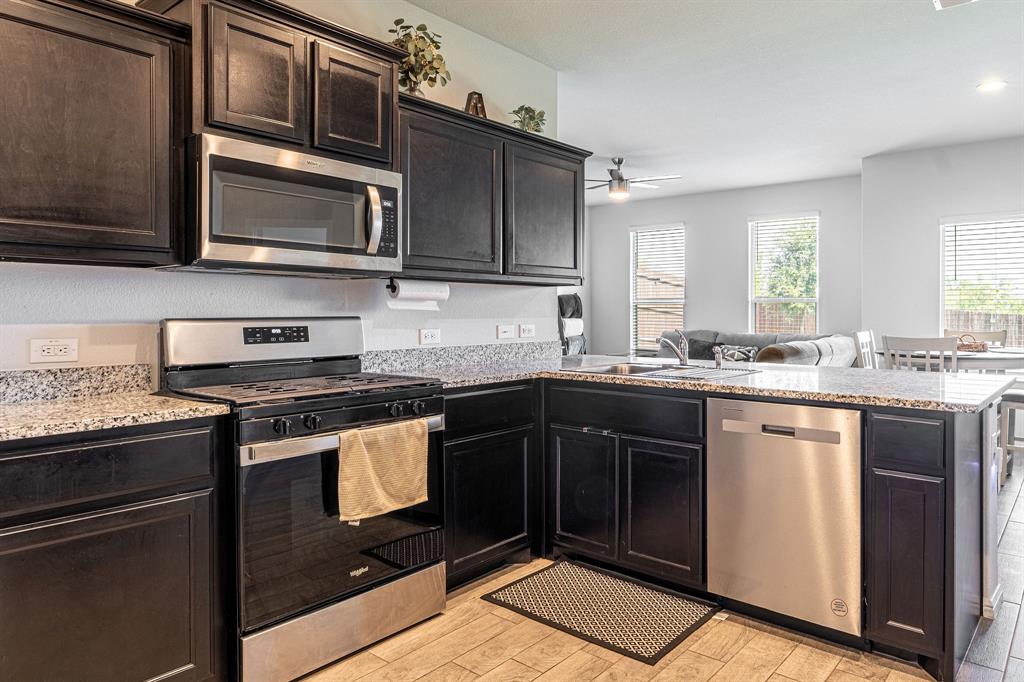 9712 Cherryville Road Fort Worth, TX 76108 - Photo 12 of 27 a kitchen with stainless steel appliances granite countertop a stove microwave and sink