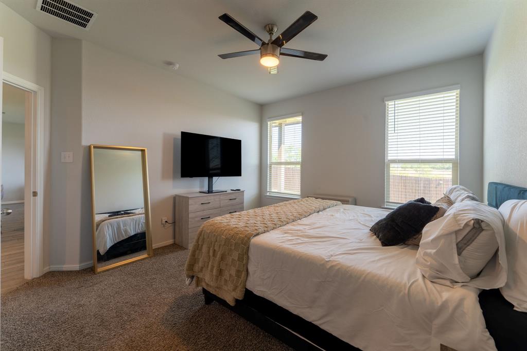 9712 Cherryville Road Fort Worth, TX 76108 - Photo 18 of 27 a bedroom with a bed and a flat screen tv