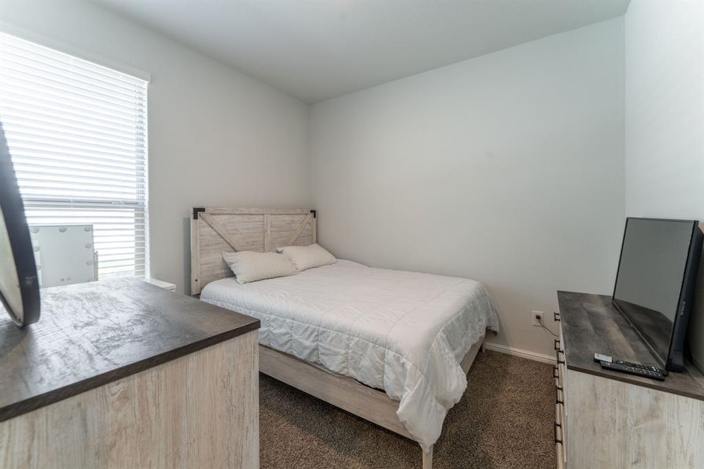 9712 Cherryville Road Fort Worth, TX 76108 - Photo 10 of 27 a bedroom with a bed tv and a window