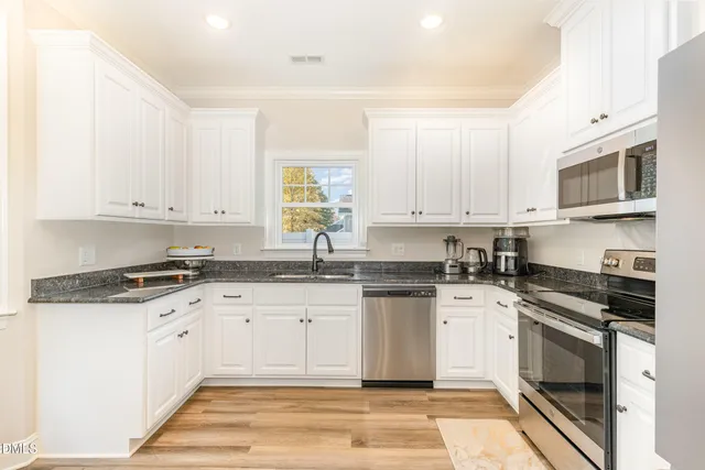 a kitchen with granite countertop white cabinets and white appliances