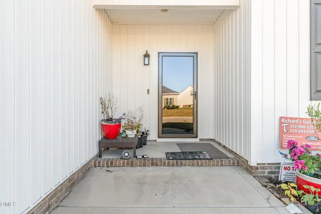 a view of a house with a yard and potted plants