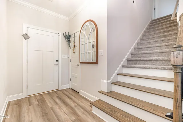 a view of a hallway with wooden floor and a potted plant