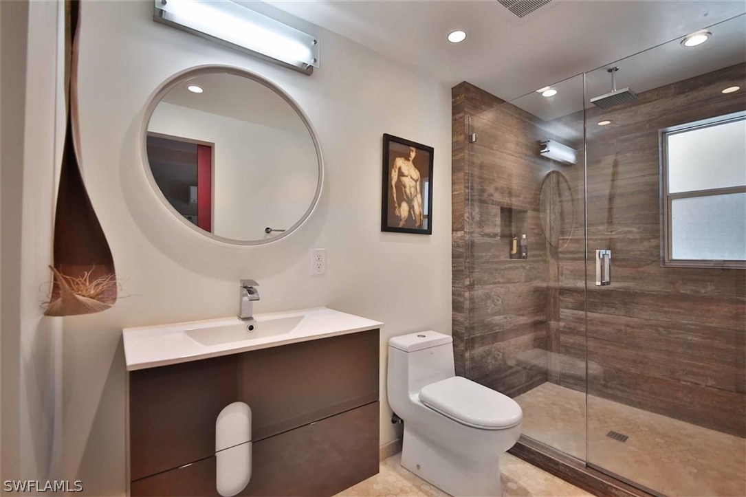 2979 Holly Road Fort Myers, FL 33901 - Photo 17 of 24 a bathroom with a toilet sink and mirror