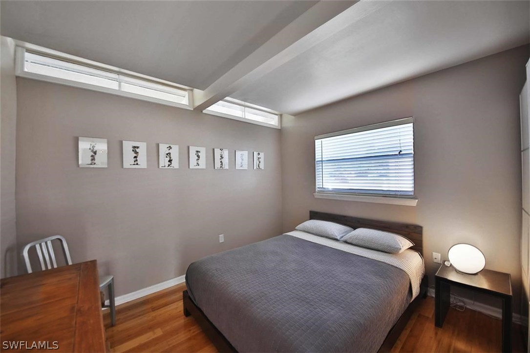 2979 Holly Road Fort Myers, FL 33901 - Photo 18 of 24 a bedroom with a bed and wooden floor