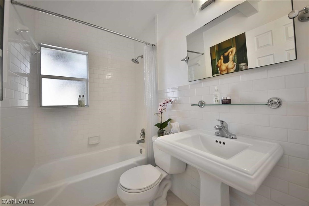 2979 Holly Road Fort Myers, FL 33901 - Photo 20 of 24 a bathroom with a sink mirror and toilet