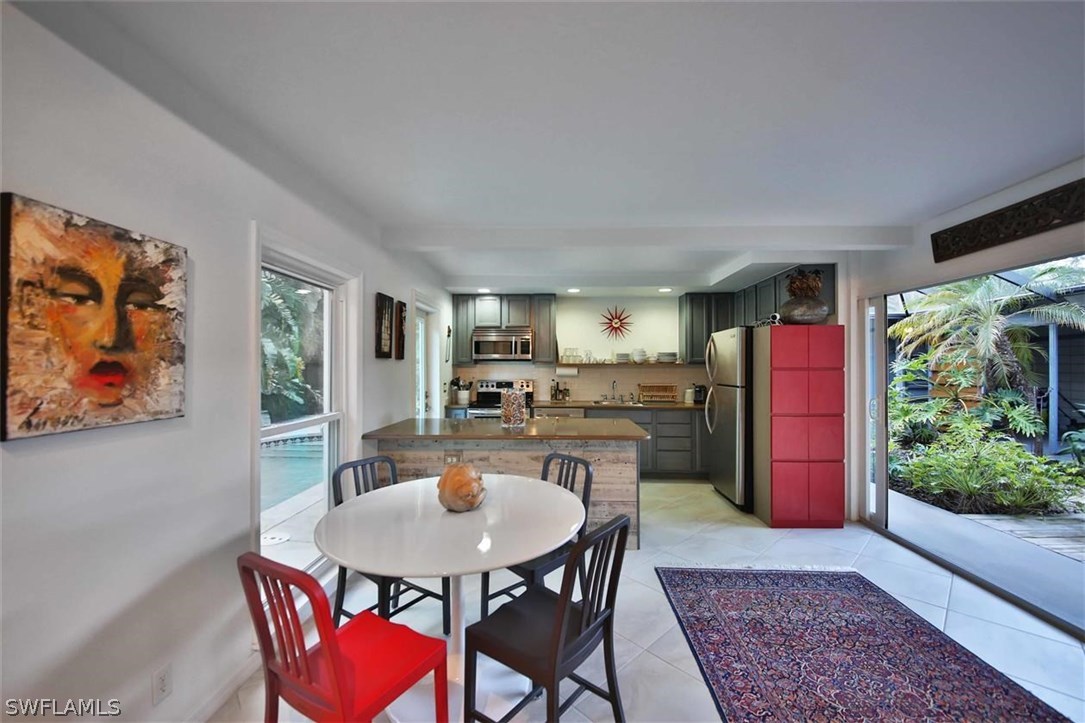2979 Holly Road Fort Myers, FL 33901 - Photo 5 of 24 a kitchen with a table chairs and a refrigerator