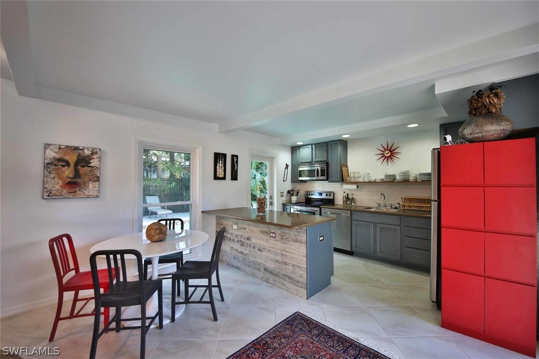 2979 Holly Road Fort Myers, FL 33901 - Photo 6 of 24 a kitchen with a dining table and chairs
