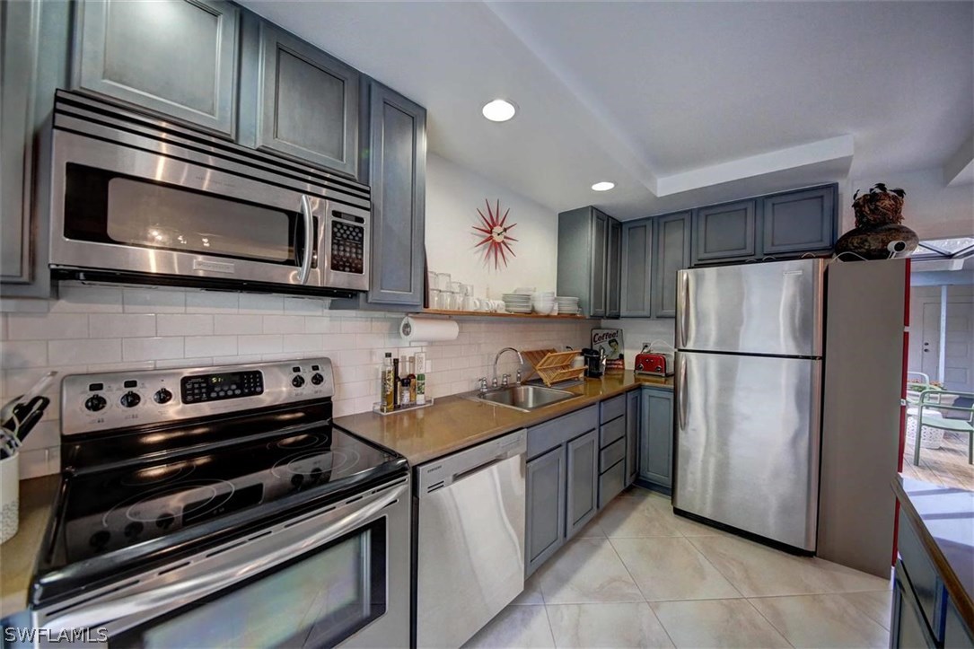 2979 Holly Road Fort Myers, FL 33901 - Photo 8 of 24 a kitchen with a refrigerator stove and microwave
