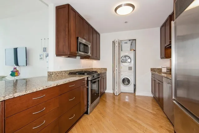 a kitchen with stainless steel appliances granite countertop a stove a sink and a refrigerator