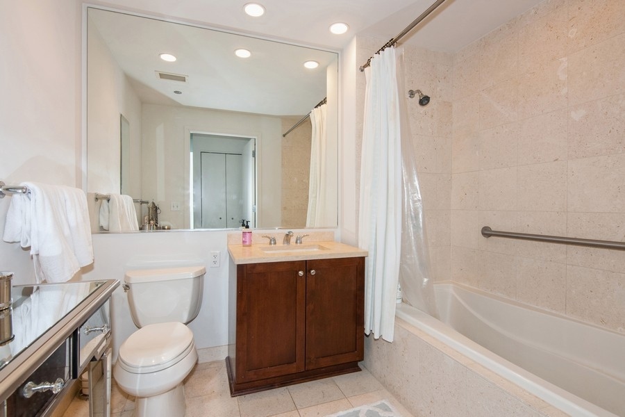 60 East Monroe Street, Unit 4006 Chicago, IL 60603 - Photo 15 of 26 a bathroom with a granite countertop sink toilet mirror and bathtub