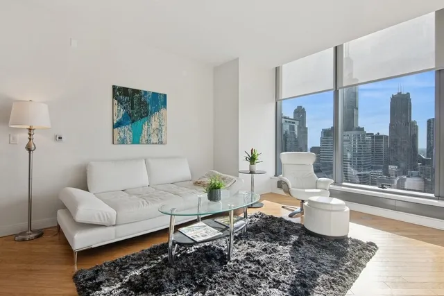 a living room with granite countertop kitchen island a table and a large window