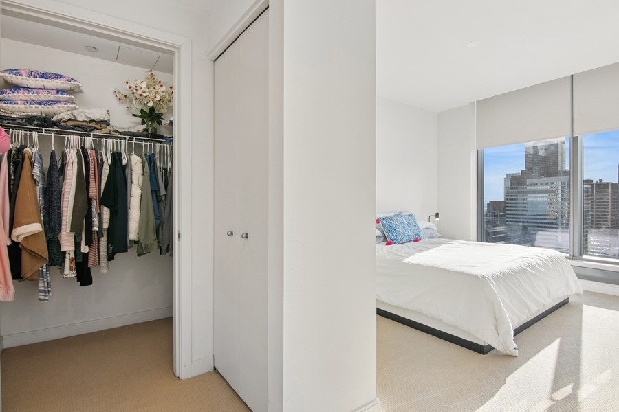 60 East Monroe Street, Unit 4006 Chicago, IL 60603 - Photo 9 of 26 a bedroom with a bed and a walk in closet