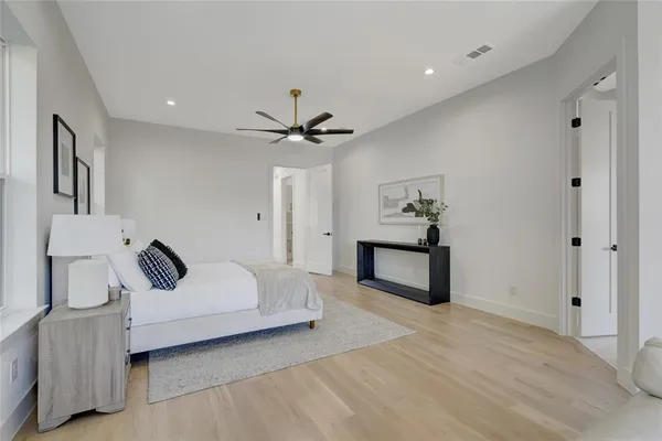 a spacious bedroom with a bed and a chandelier