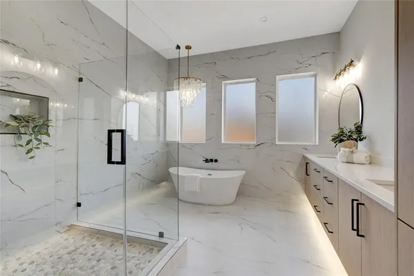 a spacious bathroom with a double vanity sink a large mirror and shower