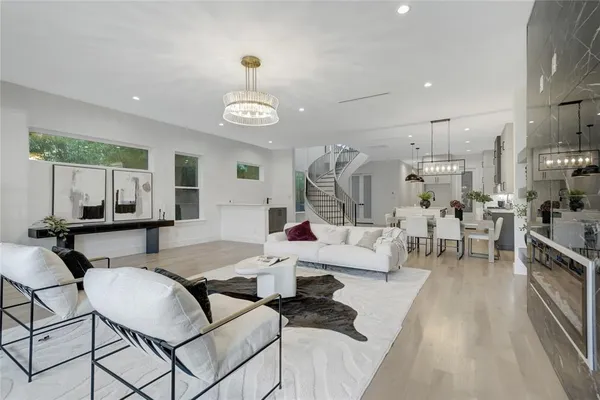 a living room with furniture kitchen view and a large window