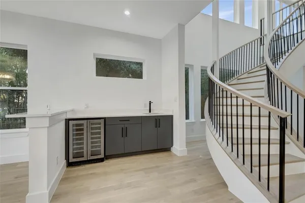 a view of a hallway with entryway and wooden floor
