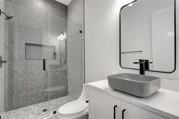 a bathroom with a sink a toilet and shower