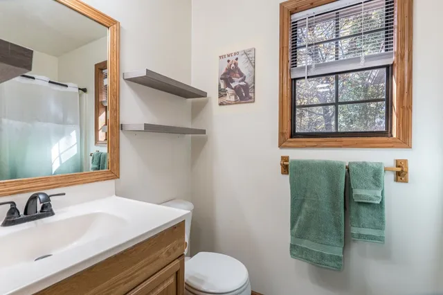 a bathroom with a sink toilet and window