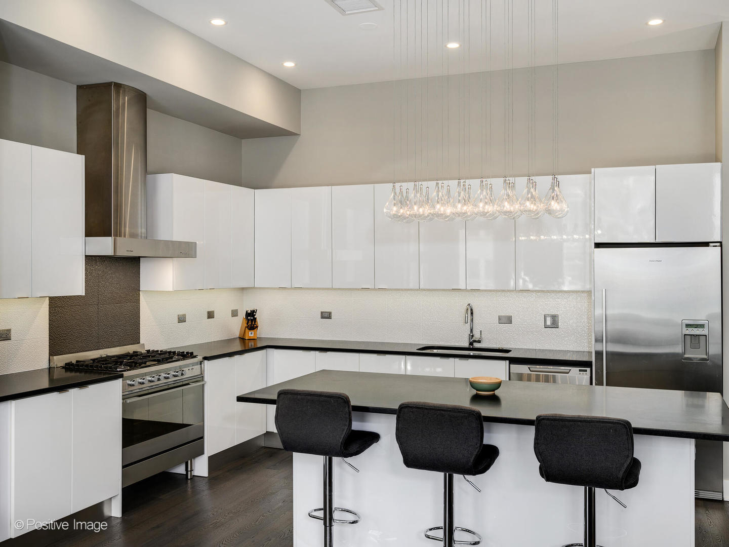 23 North Aberdeen Street, Unit 2N Chicago, IL 60607 - Photo 11 of 29 a kitchen with stainless steel appliances a sink a stove a refrigerator and white cabinets with wooden floor