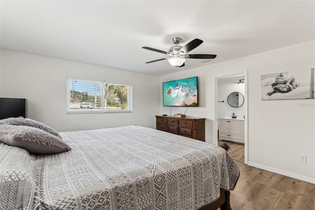 1051 Eva Street Deltona, FL 32725 - Photo 20 of 50 a bedroom with a large bed and a chandelier