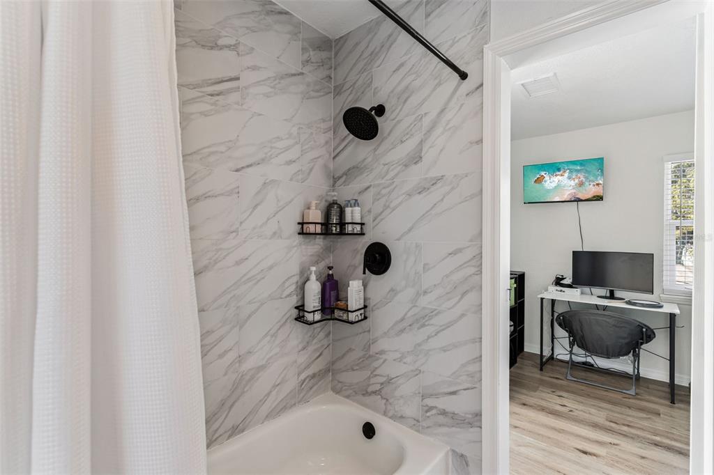 1051 Eva Street Deltona, FL 32725 - Photo 34 of 50 a bathroom with a granite countertop sink a mirror and shower