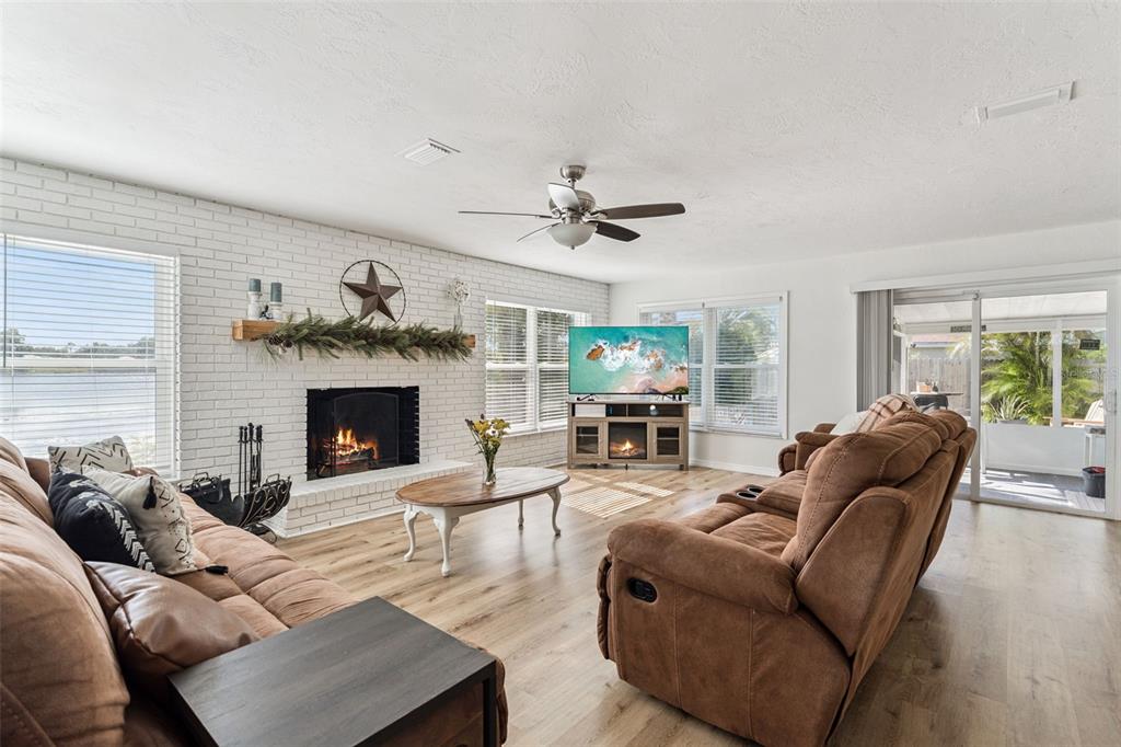 1051 Eva Street Deltona, FL 32725 - Photo 7 of 50 a living room with furniture a fireplace and a large window