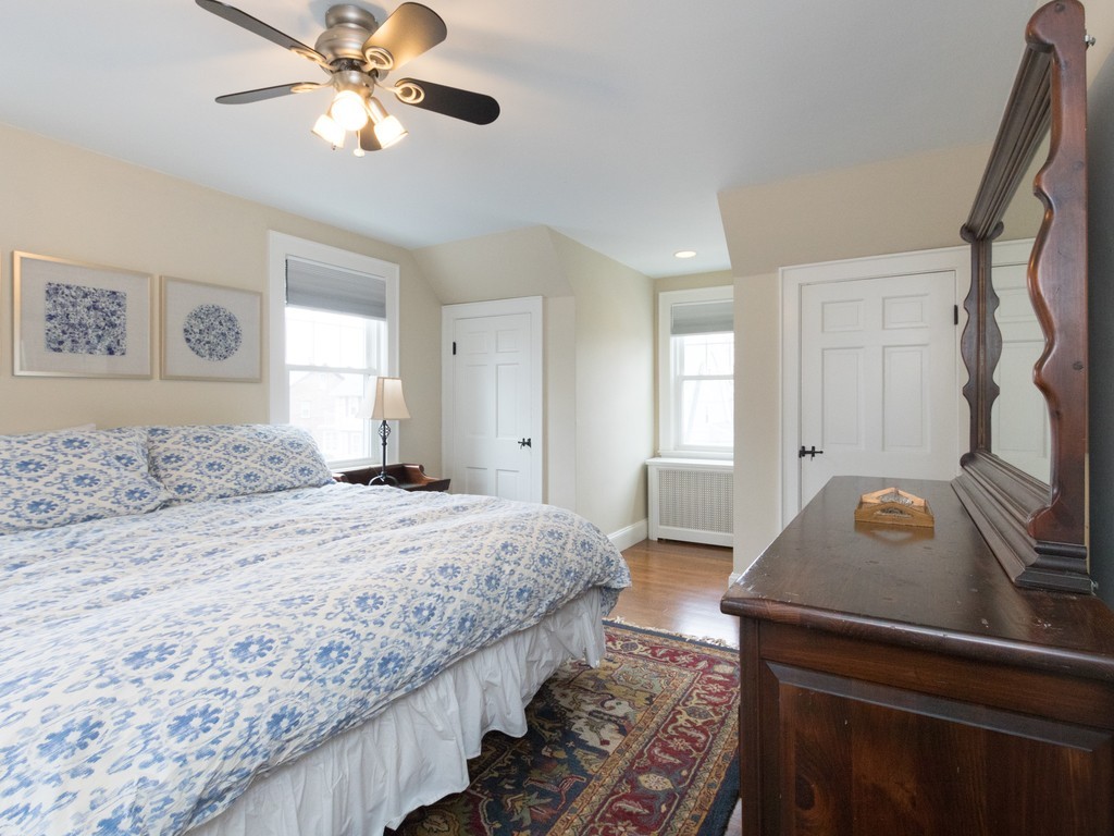 27 Churchill Road Boston, MA 02132 - Photo 18 of 30 a bedroom with a bed and a chandelier