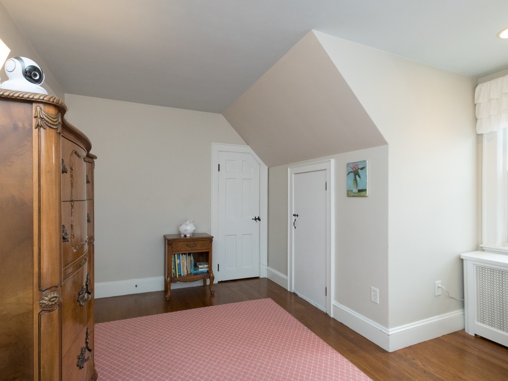 27 Churchill Road Boston, MA 02132 - Photo 22 of 30 a bedroom with a bed and wooden floor