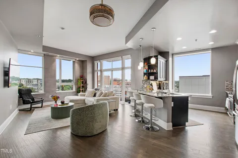 a living room with furniture wooden floor and a large window