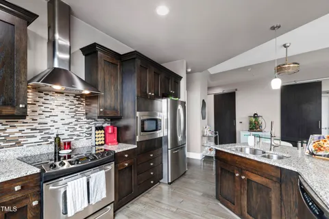a kitchen with stainless steel appliances granite countertop a sink stove and refrigerator