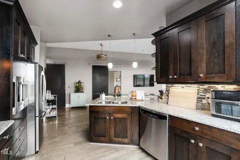 a kitchen with stainless steel appliances a sink stove and refrigerator