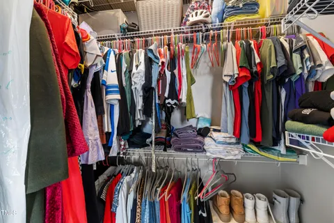 a view of walk in closet with clothes