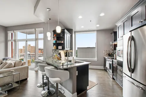 a kitchen with stainless steel appliances granite countertop a refrigerator and a stove top oven