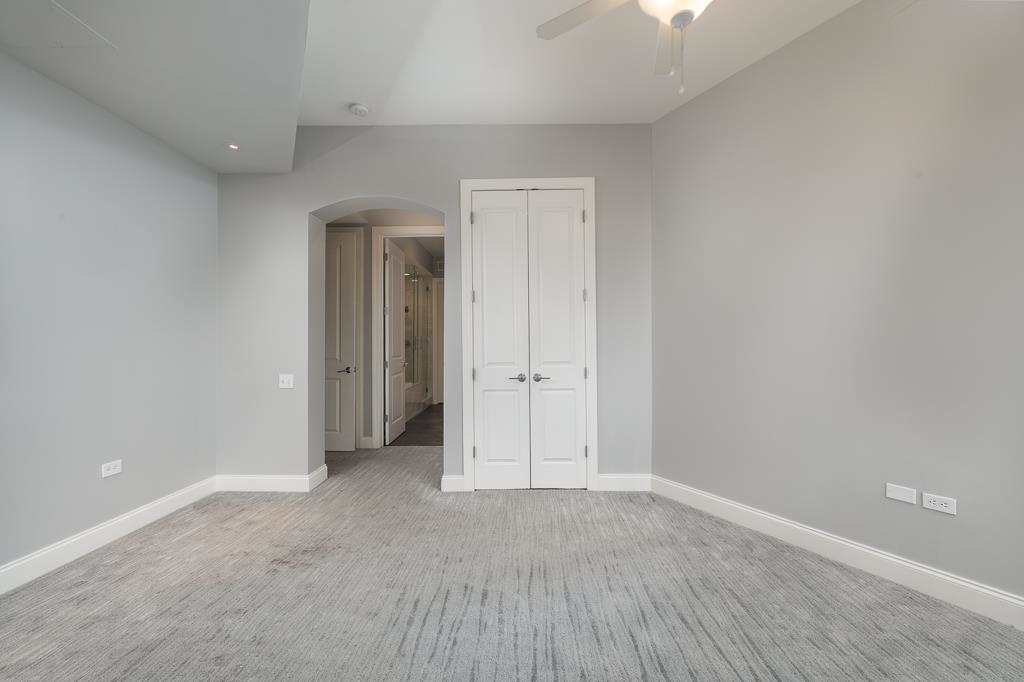 717 Riverside Drive, Unit 1105 Memphis, TN 38103 - Photo 15 of 29 Unfurnished bedroom featuring arched walkways, carpet, a closet, and a ceiling fan